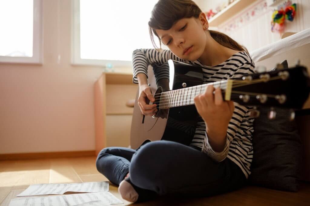 teenage girl practicing guitar